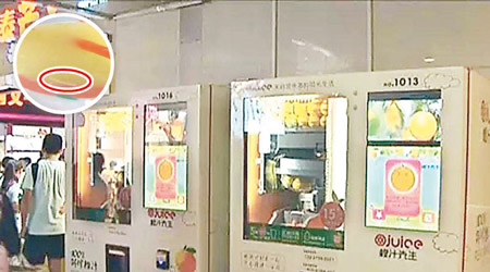 涉事的鮮榨橙汁自動售賣機。圓圖紅圈為橙汁內活蟲。（電視畫面）