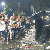 示威者用長棍攻擊警員，場面混亂。