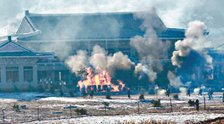 青瓦台模型被炸至起火冒煙。（北韓《勞動新聞》圖片）