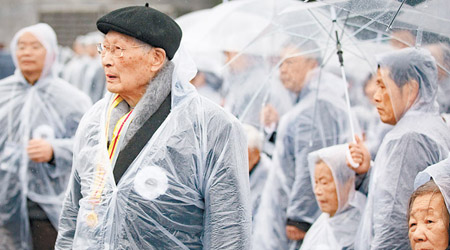南京市民紛穿上雨衣悼念死難同胞。