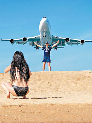 遊客在邁考沙灘近距離與飛機合照。（互聯網圖片）
