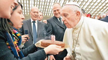 教宗（右）吹熄蛋糕上的蠟燭。
