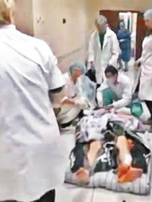 傷者躺在醫院通道的地上，等待救治。（電視畫面）