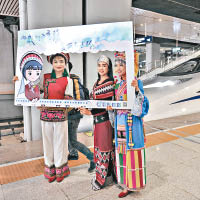 雲南少數民族代表在列車前合照。（中新社圖片）