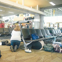 機場內的旅客瑟縮於椅子下暫避。