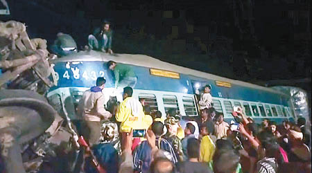 救援人員努力從火車殘骸中拯救被困乘客。