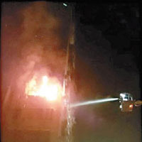高雄一住宅單位除夕夜失火，消防員到場升雲梯灌救。（互聯網圖片）