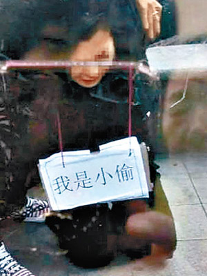 跪地女子被掛上「我是小偷」牌子。（互聯網圖片）