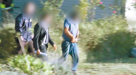 扎哈卜（右）被鎖上手銬，由警員押送至法庭。（澳洲警方圖片）