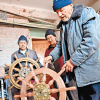 米哈爾斯基（中）與眾人展示用於帆船的船舵。