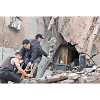 建築物被炸開一個大洞，警員在現場搜證。