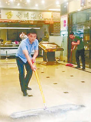 大水退後，珠寶店店員清理商場內積水。（互聯網圖片）