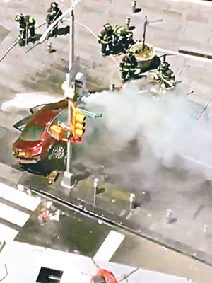 汽車衝上行人路後不斷冒煙，消防員射水撲救。（互聯網圖片）