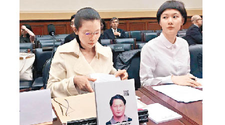 李凈瑜（左）在席上展示丈夫的照片。（互聯網圖片）