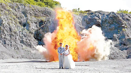夫婦身後爆出巨大火球，烈燄直沖上天。（互聯網圖片）