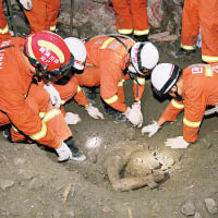 救援人員在沙泥中發現一具遺體。（中新社圖片）