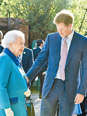哈利（右）表示因英女王（左）而留在皇室。（資料圖片）