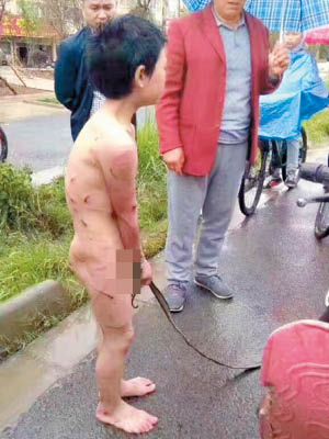 男童全身赤裸站在大街上，雙手遭繩綑綁。（互聯網圖片）