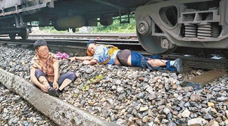 徐前凱（右）成功將老婦（左）推出路軌，自己的右腿卻被列車輾過。（互聯網圖片）