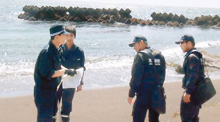 日本警方在發現女屍的海邊調查。（互聯網圖片）