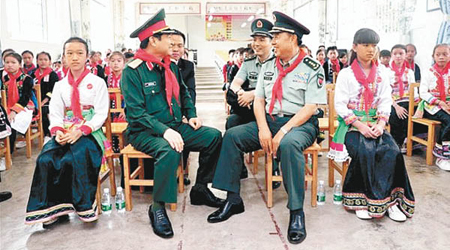 范長龍（右二）與吳春歷（左二）在金水河口岸邊境小學交談。（互聯網圖片）