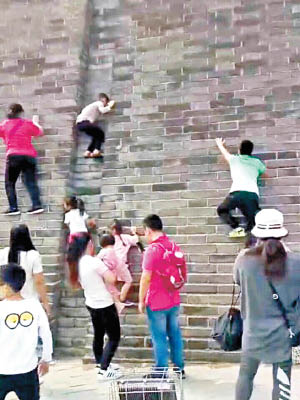 攀爬城牆的除了小童外，還有大人。（互聯網圖片）