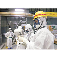 核電站內輻射超標，工作人員須穿保護衣工作。