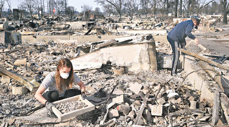 災民到被燒毀的舊居檢拾物品。（美聯社圖片）