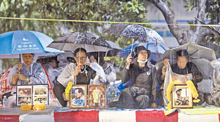 民眾不畏風雨暴曬，在路邊守候。（美聯社圖片）