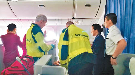 醫務人員在機艙為女乘客檢查。（互聯網圖片）