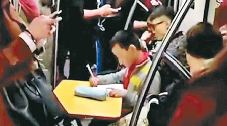 男童在地鐵開枱做功課引熱議。（互聯網圖片）