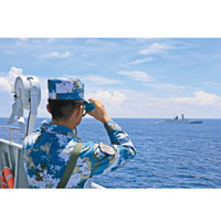 一名中國海軍用望遠鏡視察南海環境。（資料圖片）