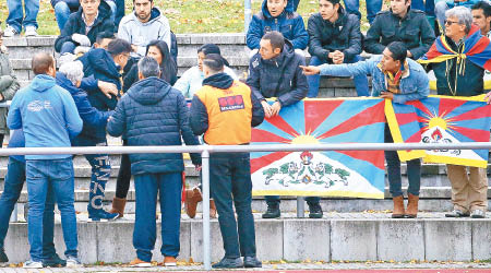 觀眾席上有人持「雪山獅子旗」抗議，引起中國球員不滿拒絕作賽。（美聯社圖片）