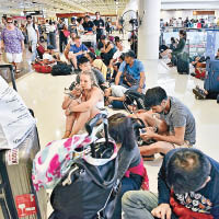 伍拉‧賴國際機場多班航機取消，大批旅客在機場等候。（美聯社圖片）