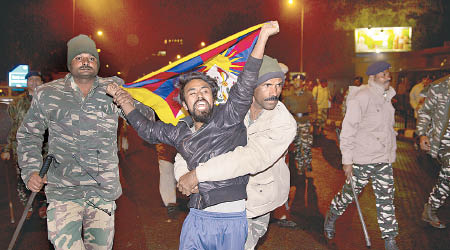 示威藏人高舉雪山獅子旗，被警方拘捕。（美聯社圖片）