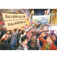 示威者舉起標語，反對《勞基法》修正草案。（中時電子報圖片）