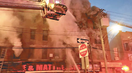消防員趕到布朗克斯起火公寓灌救。（美聯社圖片）