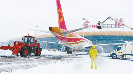 安徽<br>合肥新橋機場的工人忙於清理飛機和跑道上積雪。（中新社圖片）