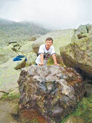 朱曼的長子與隕石合照。（互聯網圖片）