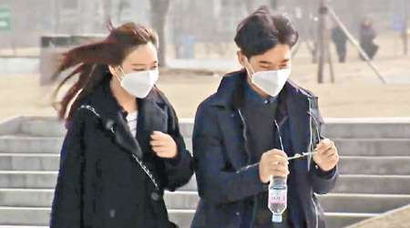 首爾受霧霾籠罩，民眾戴口罩上街。（電視畫面）