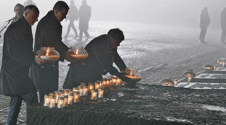 波蘭政府高層為死者點起燭光。（美聯社圖片）