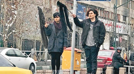 伊朗兩名女子脫下頭巾示威。（互聯網圖片）