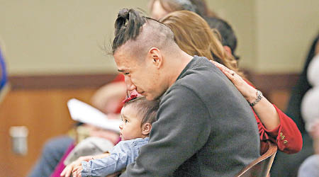 馬西尼抱着女兒聽審時一臉悲痛。（美聯社圖片）