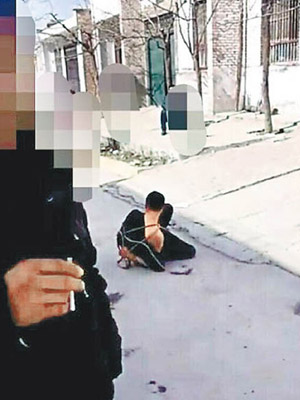 陝西涉案男子被綑綁四肢壓在地。（互聯網圖片）