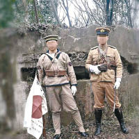 兩人手持武器及日本旗。