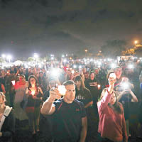 民眾手持蠟燭悼念槍擊案死者。（美聯社圖片）
