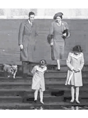 伊利沙伯（前排右）與家人及皇室首隻哥基犬散步。（互聯網黑白圖片）