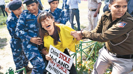 流亡西藏組織成員到中國使館前示威，有女成員被帶走。（美聯社圖片）
