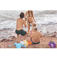 孕婦生產後走上沙灘與家人會合。（互聯網圖片）