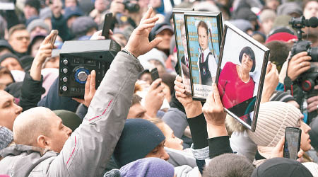 民眾示威抗議，並高舉遇難者的照片。
